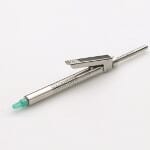 A Paroject® PDLA Dental Cartridge Syringe by Ronvig, featuring a silver metal body, pocket clip, and light green tip for intraligamental anesthesia, is shown lying on a white surface.