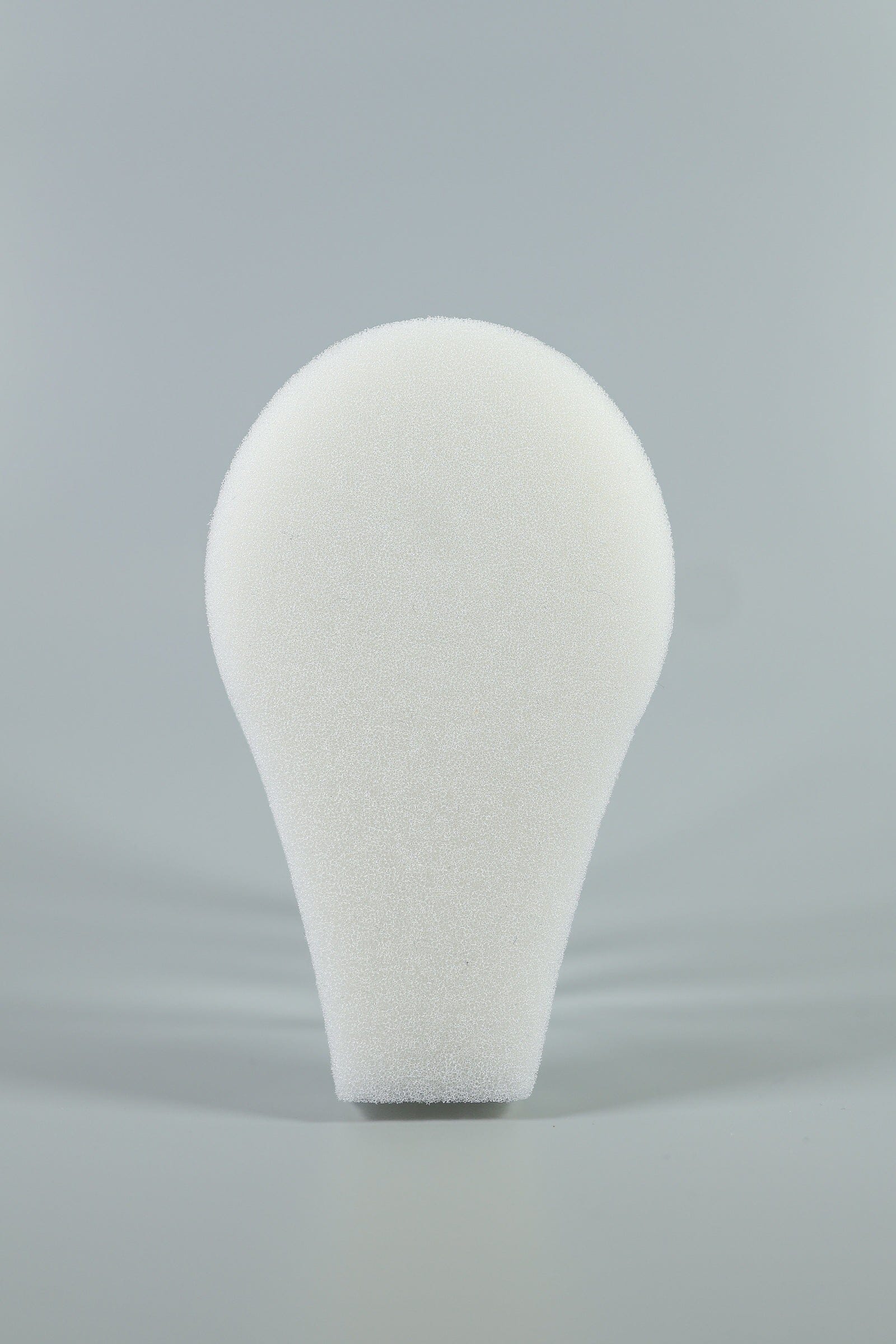 A white, teardrop-shaped C-Sponge II Surgical Throat Pack with integrated retrieval extension by Xemax is shown upright against a plain gray background.