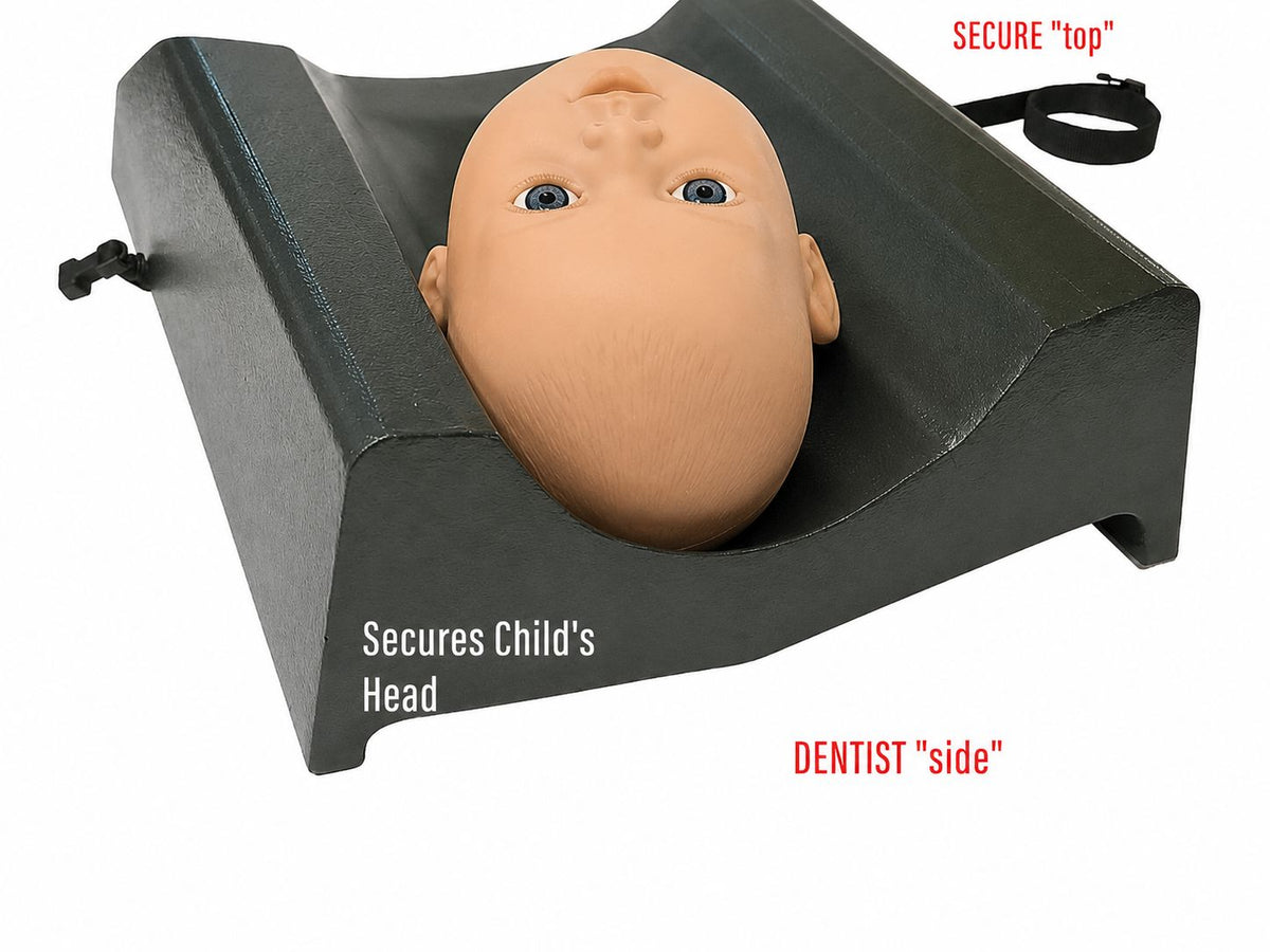 A mannequin child's head rests in the Mediposture Knee-To-Knee Exam Cradle, a contoured black stabilizer labeled “Secures Child’s Head,” “SECURE ‘top’,” and “DENTIST ‘side’.” Straps offer safer support during pediatric dental exams.