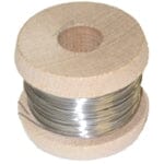 A spool of Delco Stainless Steel Ligature Wire by Delco, wrapped around a cylindrical wooden reel with a hole in the center.