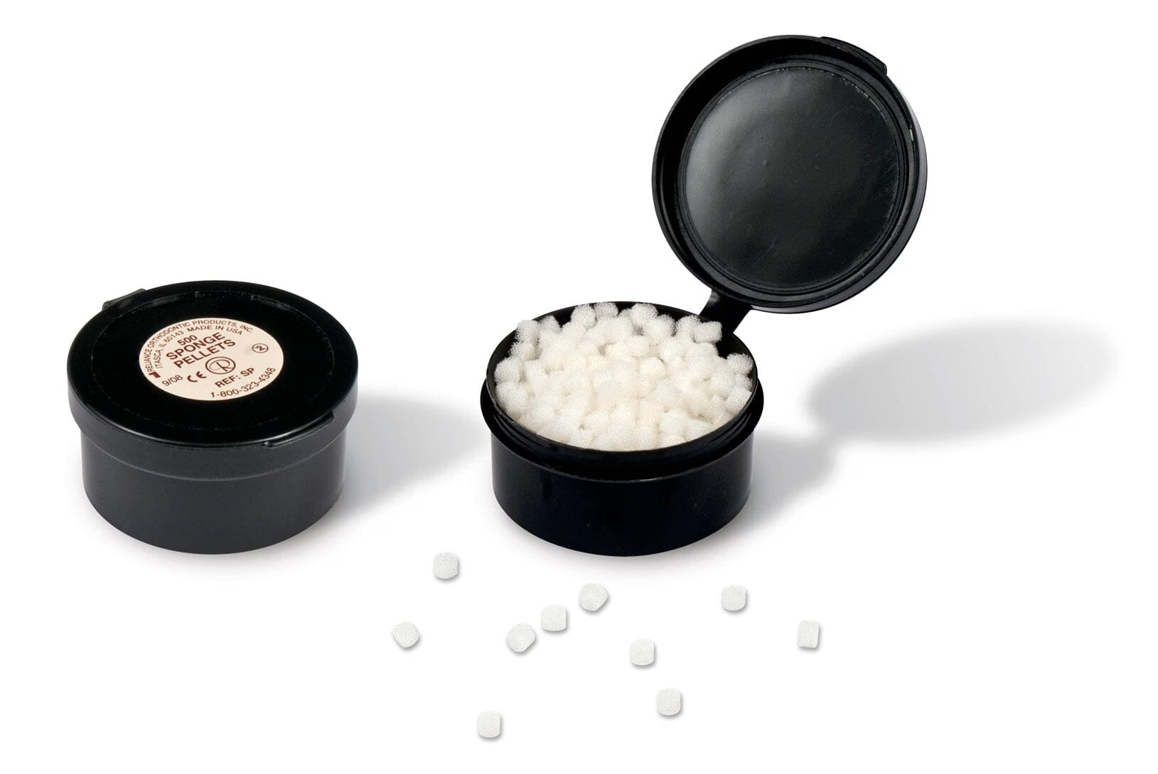 Two small black Reliance Etchant Sponge Pellets containers (one open, one closed) display white pellets inside. Several Reliance sponge pellets are scattered on the white surface in front. Pack contains 500