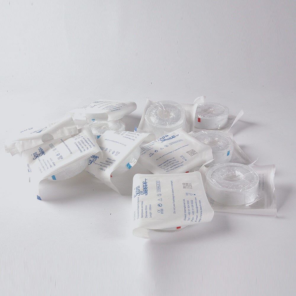 Several individually wrapped Sani-Sleeve Sterile Handpiece & Equipment Cover Sleeves by Xemax, designed for barrier protection, are scattered on a white surface with clear labeling and blue text on the packaging.