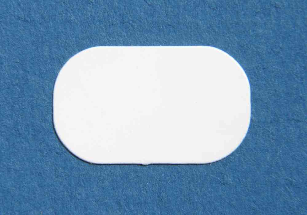 A Cytoplast GBR-200 Original dPTFE Membrane, a small white rounded-rectangle patch by Cytoplast, rests on a blue textured surface.