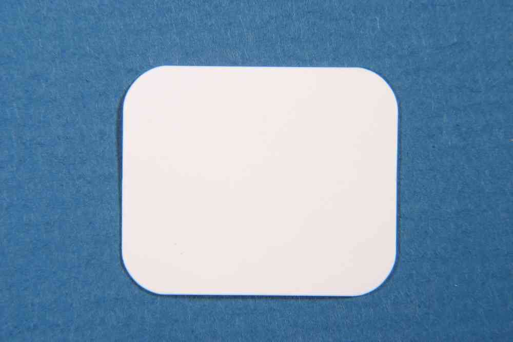 A Cytoplast GBR-200 Original dPTFE Membrane by Osteogenics, resembling a plain white rectangular card with rounded corners, is placed on a blue textured surface.