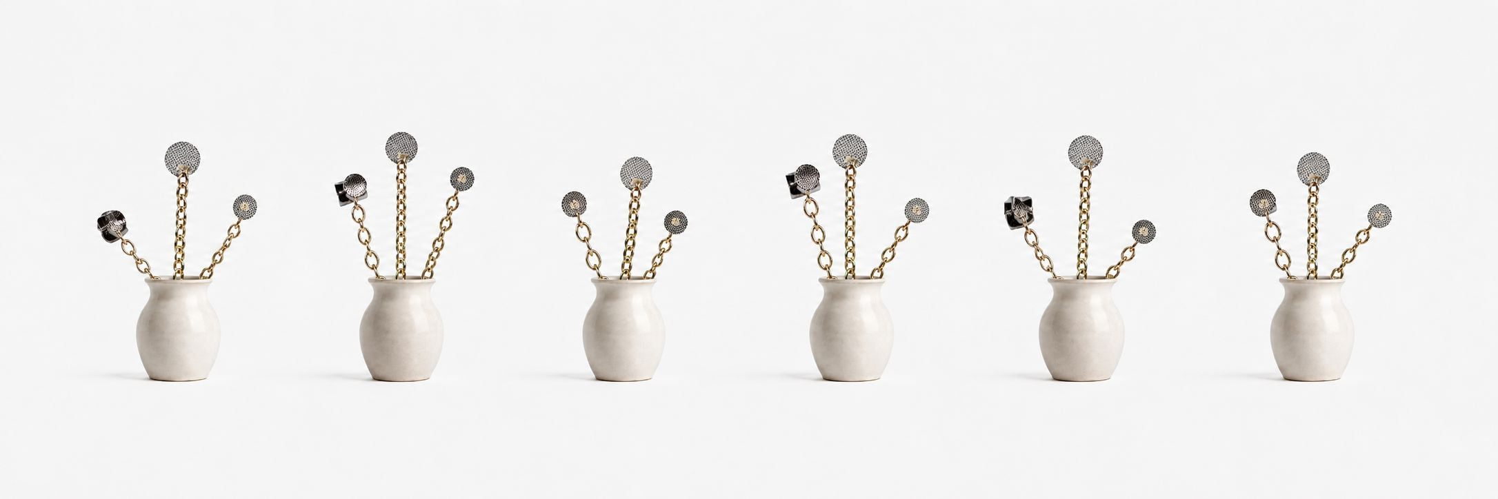Five identical white vases, each containing gold chain stems topped with circular, metallic, flower-like ornaments, are evenly spaced against a plain white background.