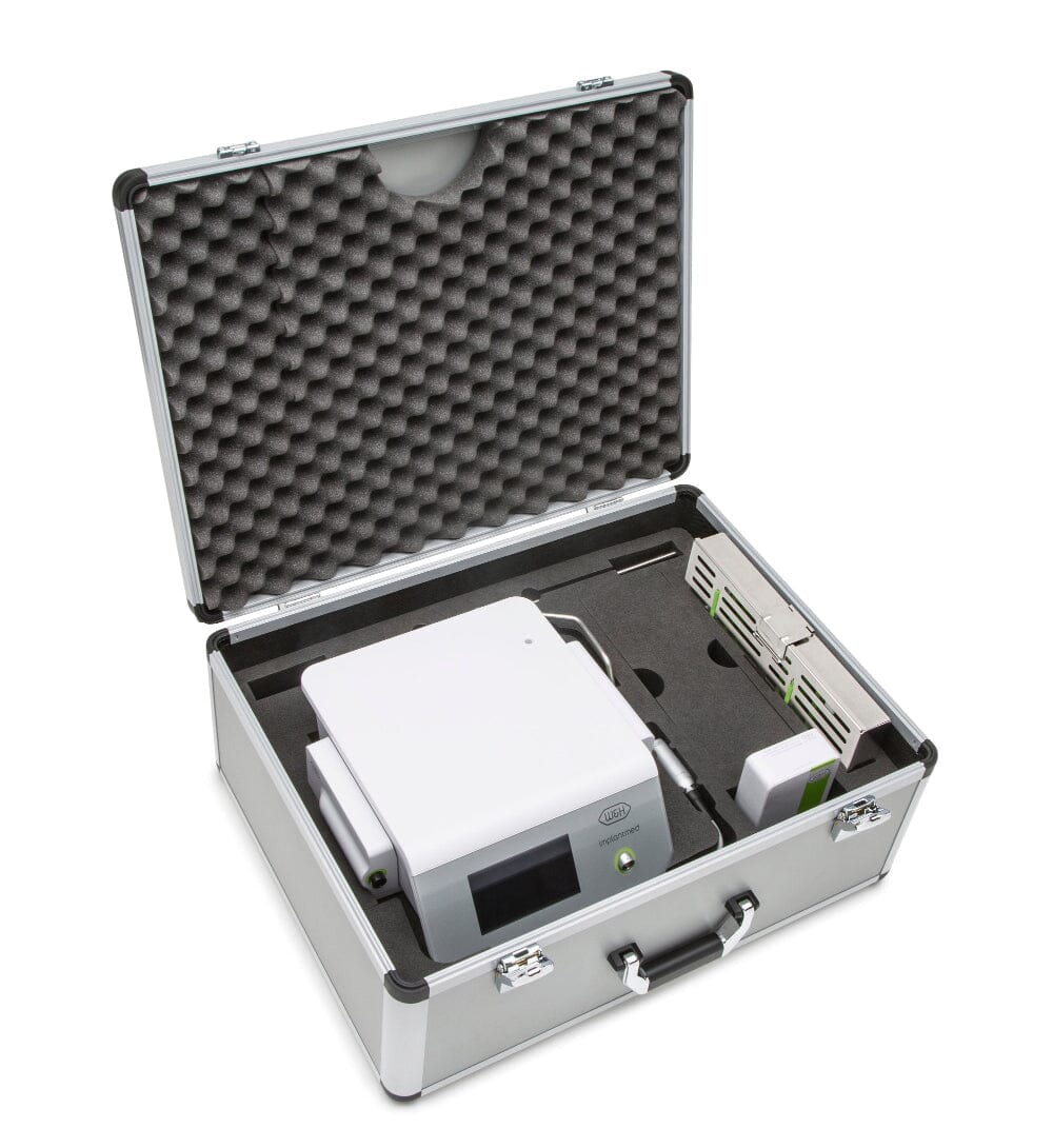 A W&H Implantmed Plus / Classic / Amadeo Briefcase in silver with black foam padding displays a white device, adapter, and accessories neatly placed in custom cutouts, shown with the lid open.