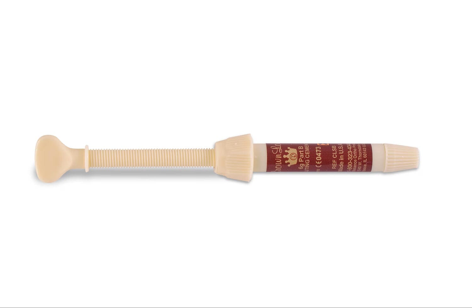 A beige plastic "Crown Lok Self-Curing Metal Luting Cement Part B" syringe by Reliance, featuring a brown label with white text, lies horizontally with its plunger extended and nozzle capped on a white background.