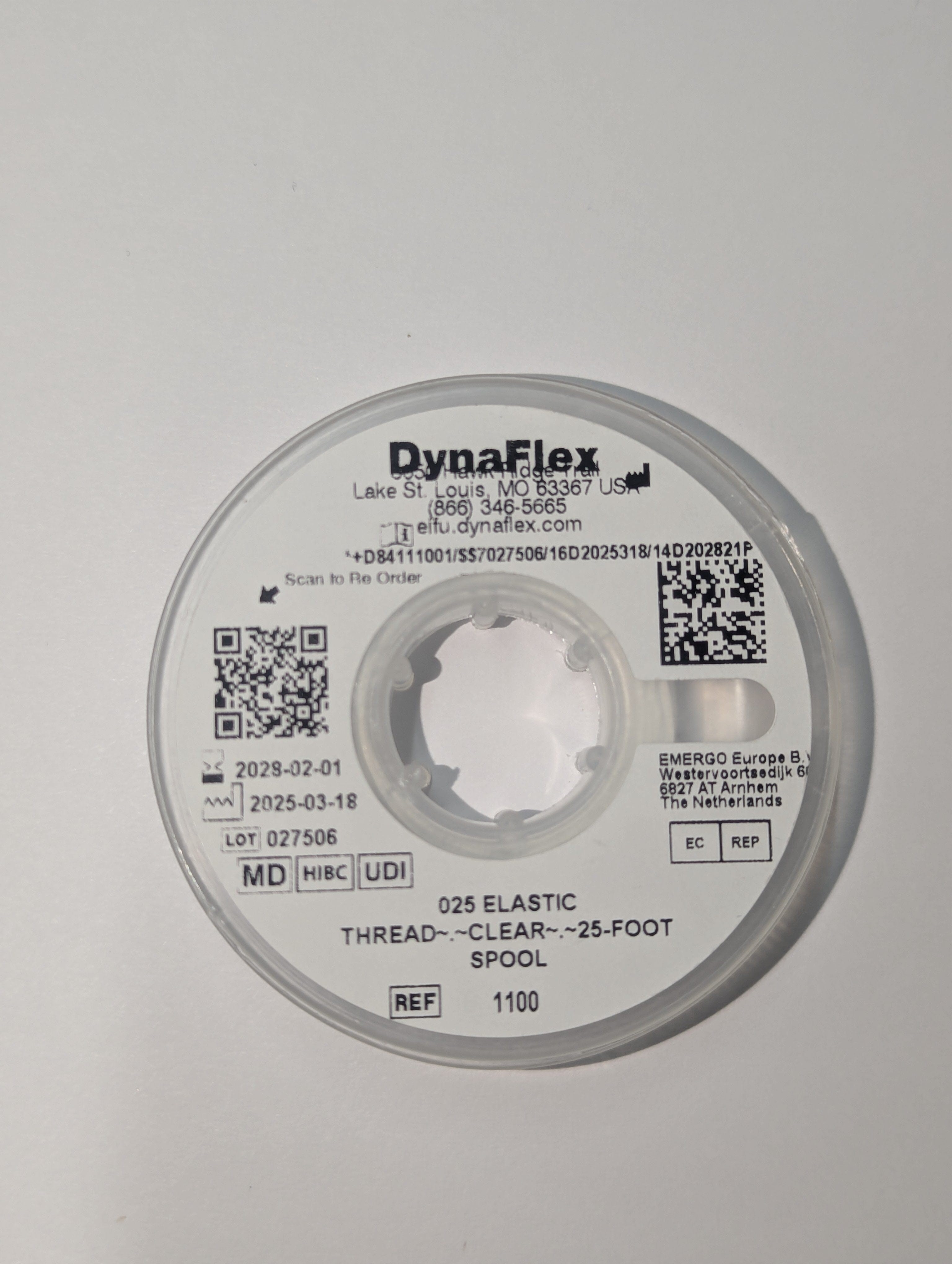 A spool of Orthodontic Elastic Power Thread by Dynaflex, latex-free, 25 feet long, features barcodes, QR codes, and expiration dates on its packaging.