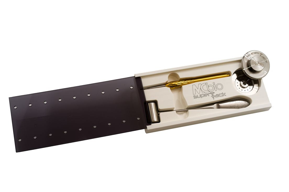 The McBio SuperTack Set comes in a white box with a sliding black lid and includes a stethoscope, reflex hammer, tuning fork, and gold percussion hammer, each organized neatly in molded slots.