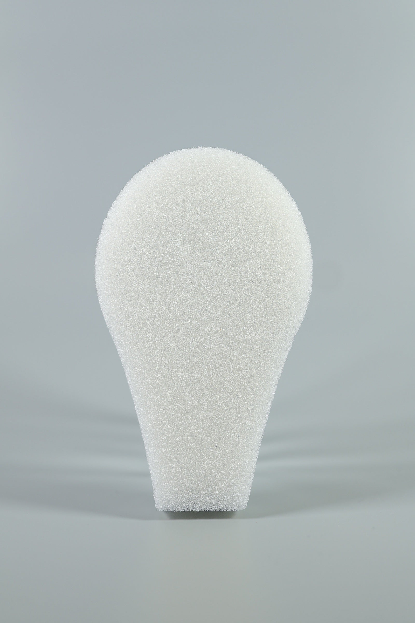 A white, teardrop-shaped C-Sponge II Surgical Throat Pack with integrated retrieval extension by Xemax is shown upright against a plain gray background.