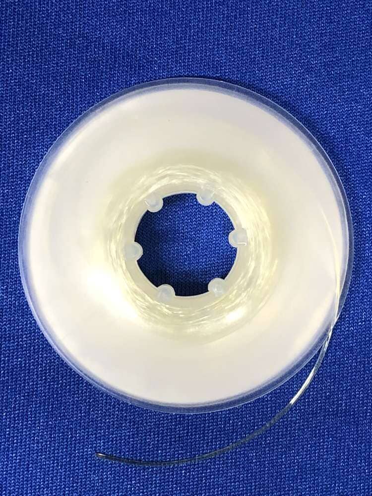 A spool of Dynaflex Orthodontic Elastic Power Thread, made from latex-free material, is displayed on a blue textured fabric background.