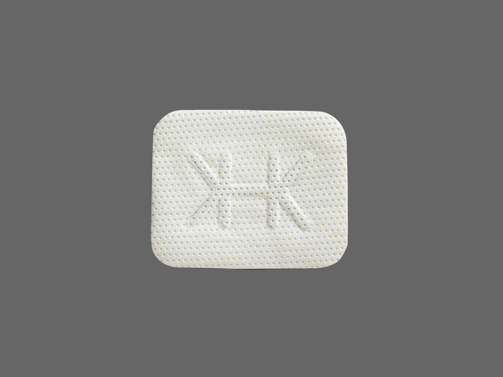 A white, square pill with rounded corners and embossed double K's mirrors the precision of Osteogenics' Cytoplast™ Ti-250 Titanium-Reinforced PTFE Membrane (250 μm), set against a plain gray background.