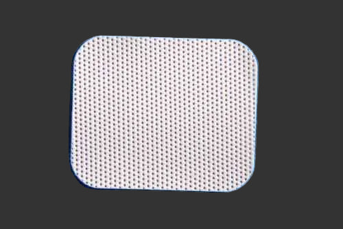 The Osteogenics Cytoplas TXT Non-Resorbable High-Density PTFE Membrane, a white, rectangular sheet with rounded corners and small perforations, is shown on a textured blue surface.
